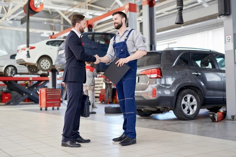 Worker shaking hands with client in car service shop - Guru Harkishan Motors Delhi